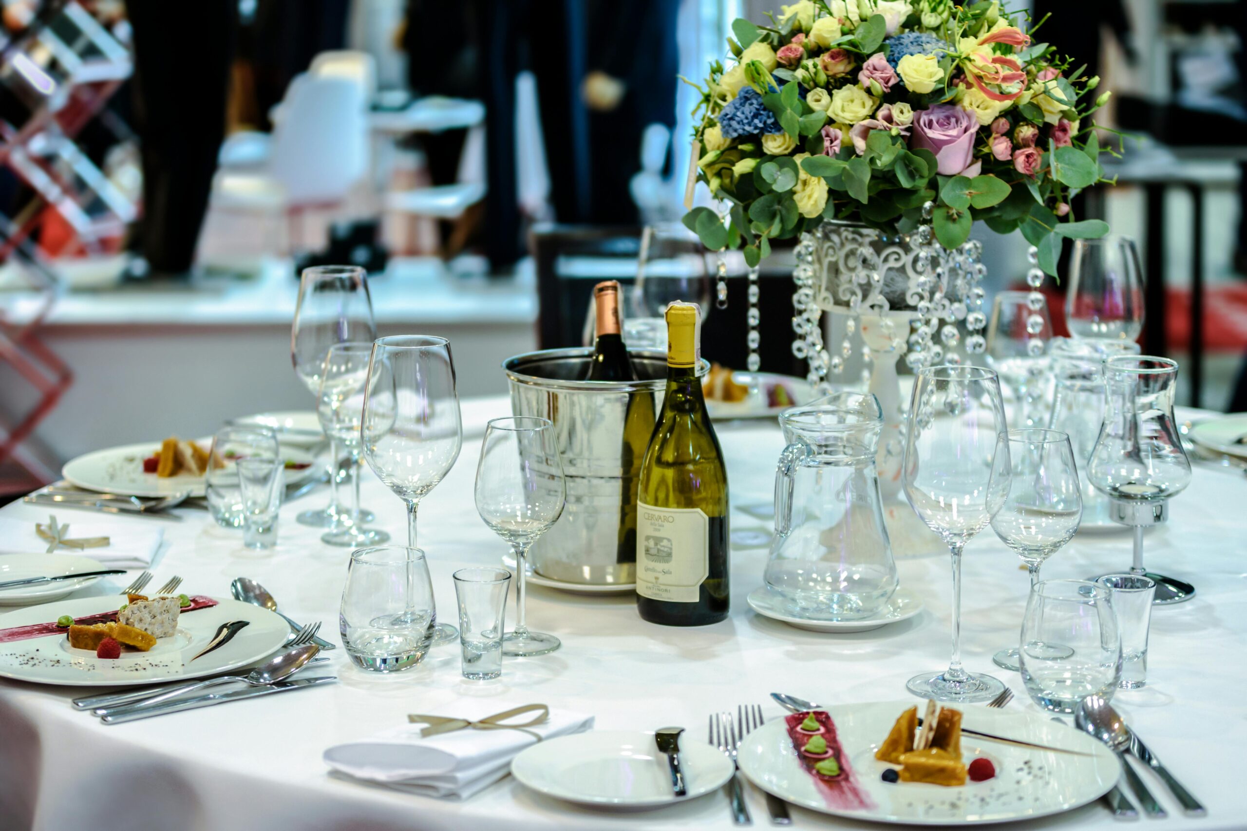 Home Luxurious dining setup with flowers, wine, and dessert plates, ideal for special occasions.