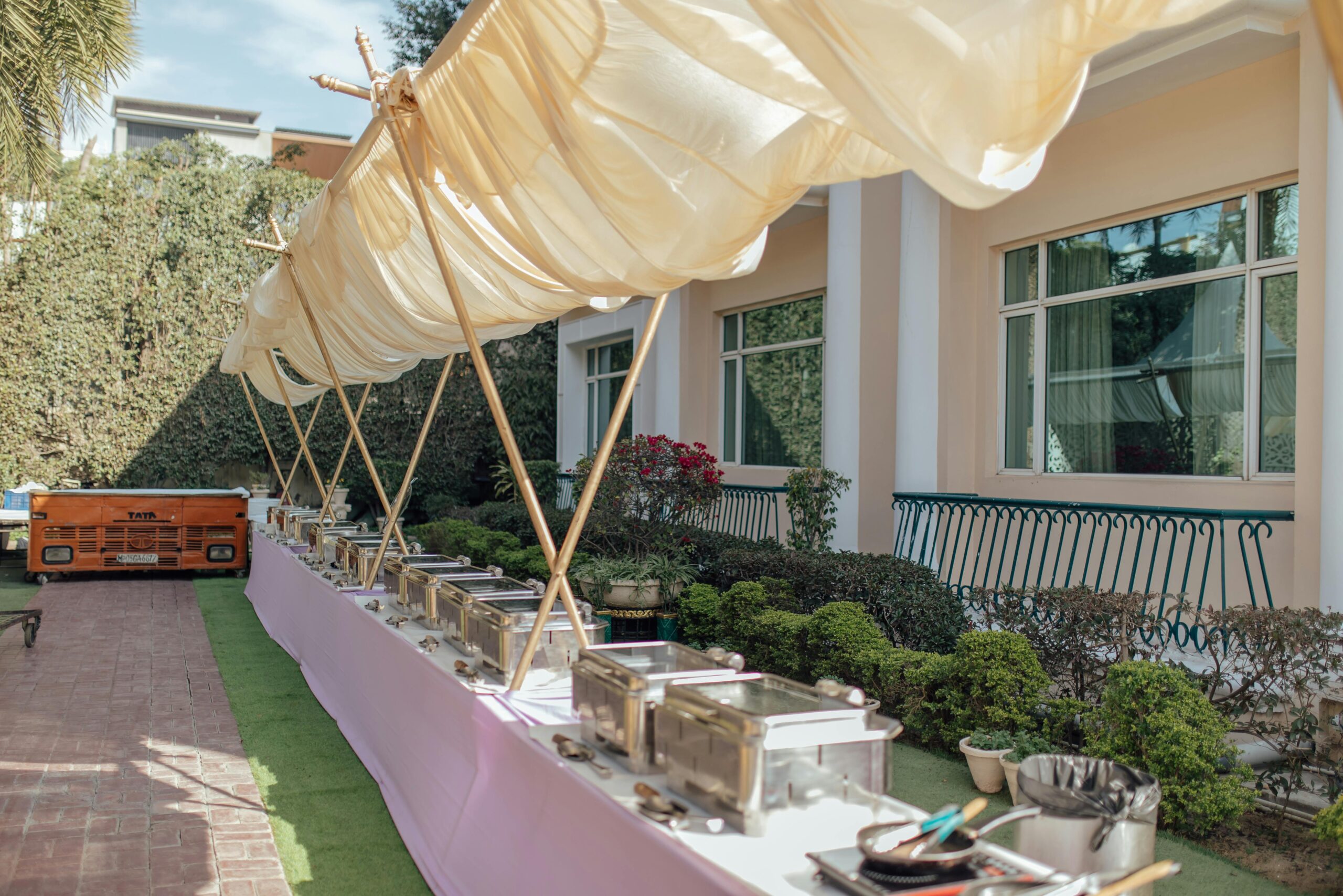 Home Elegant outdoor buffet setup with chafing dishes and canopy. Perfect setting for a garden party or wedding reception.
